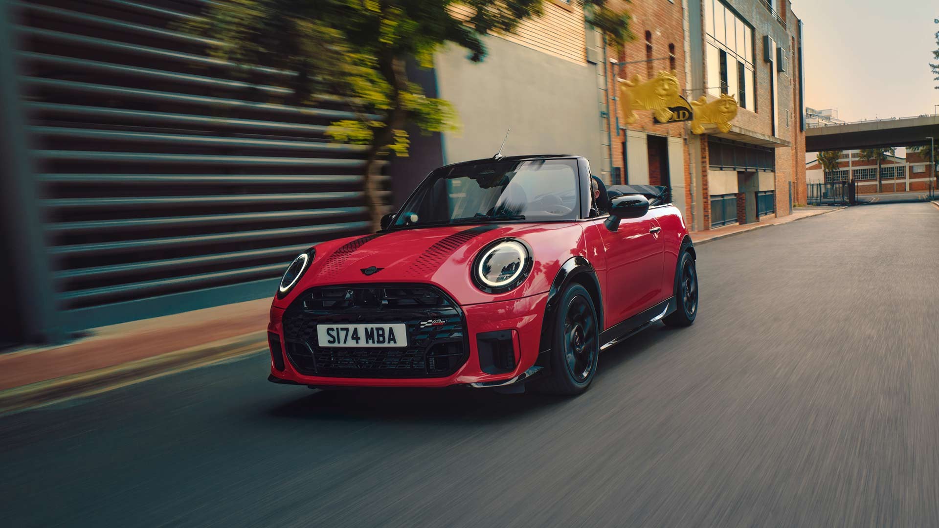 Heckansicht eines fahrenden MINI Cooper Cabrio in Copper Grey 